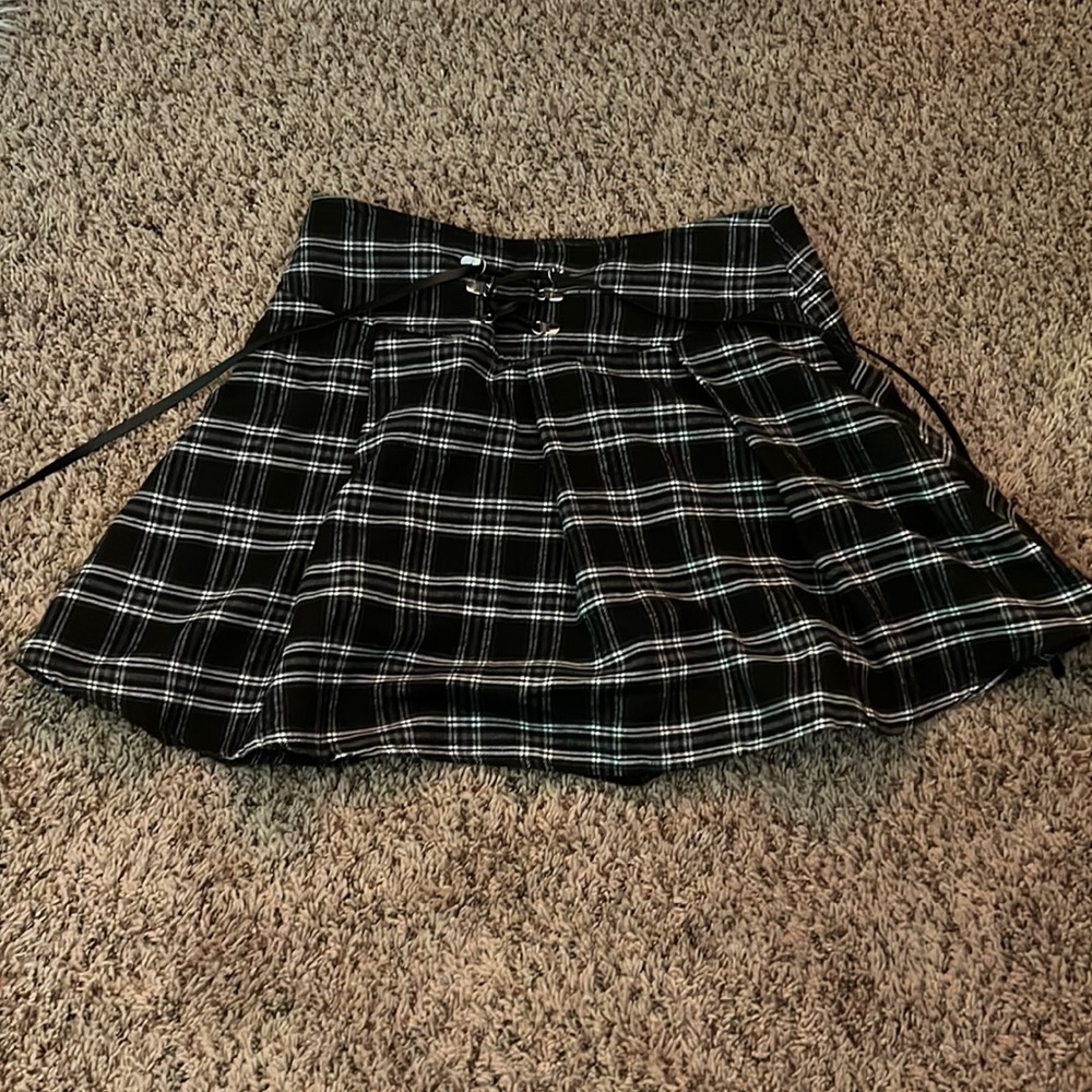 black, flannel-patterned flowy miniskirt with ties on the back